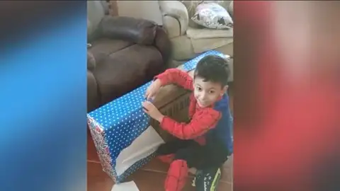 Un niño abriendo un regalo de Papá Noel Un niño abriendo un regalo de Papá Noel