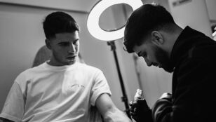 Carlos Alcaraz haci&eacute;ndose un tatuaje