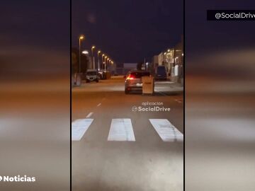 Un coche conduce con un contenedor atado a su maletero en Cartagena