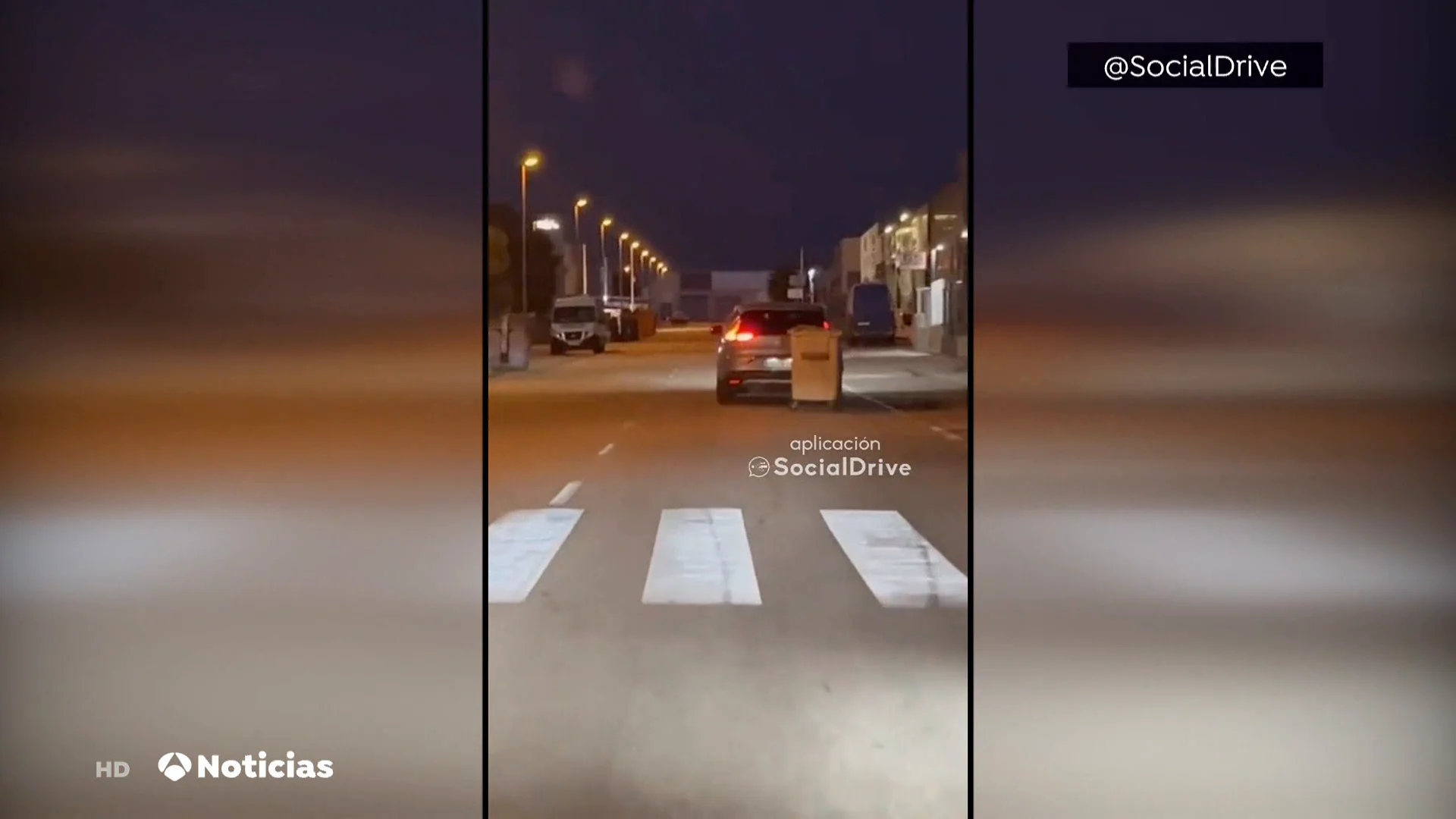 Un coche conduce con un contenedor atado a su maletero en Cartagena