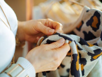 Mujer revisando el agujero de un jersey