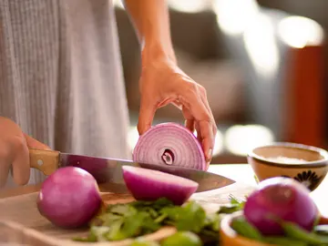 Una persona cortando cebolla en la cocina. Una persona cortando cebolla en la cocina.