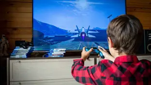 Imagen de archivo de un niño jugando a videojuegos Imagen de archivo de un niño jugando a videojuegos