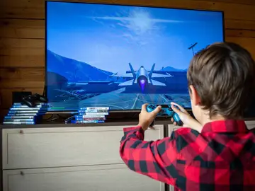 Imagen de archivo de un niño jugando a videojuegos Imagen de archivo de un niño jugando a videojuegos