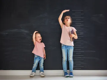 Dos niñas miden su estatura Dos niñas miden su estatura