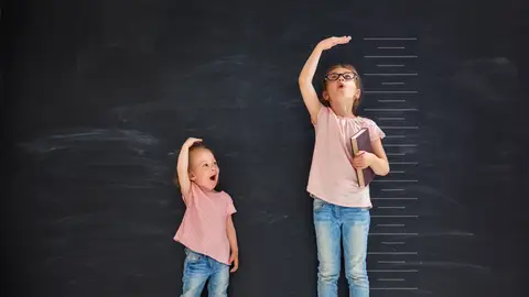 Dos niñas miden su estatura Dos niñas miden su estatura