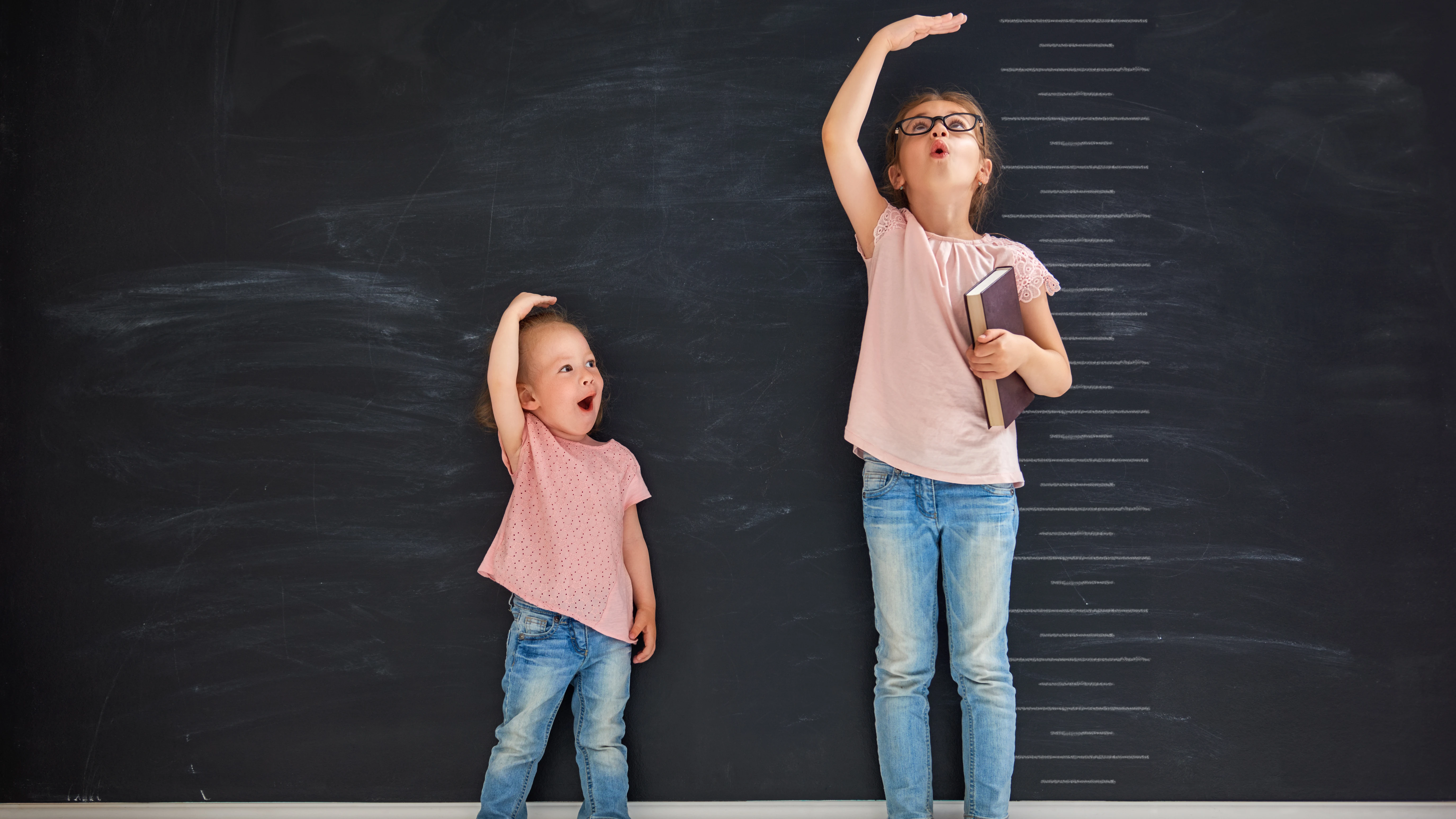 Dos niñas miden su estatura Dos niñas miden su estatura