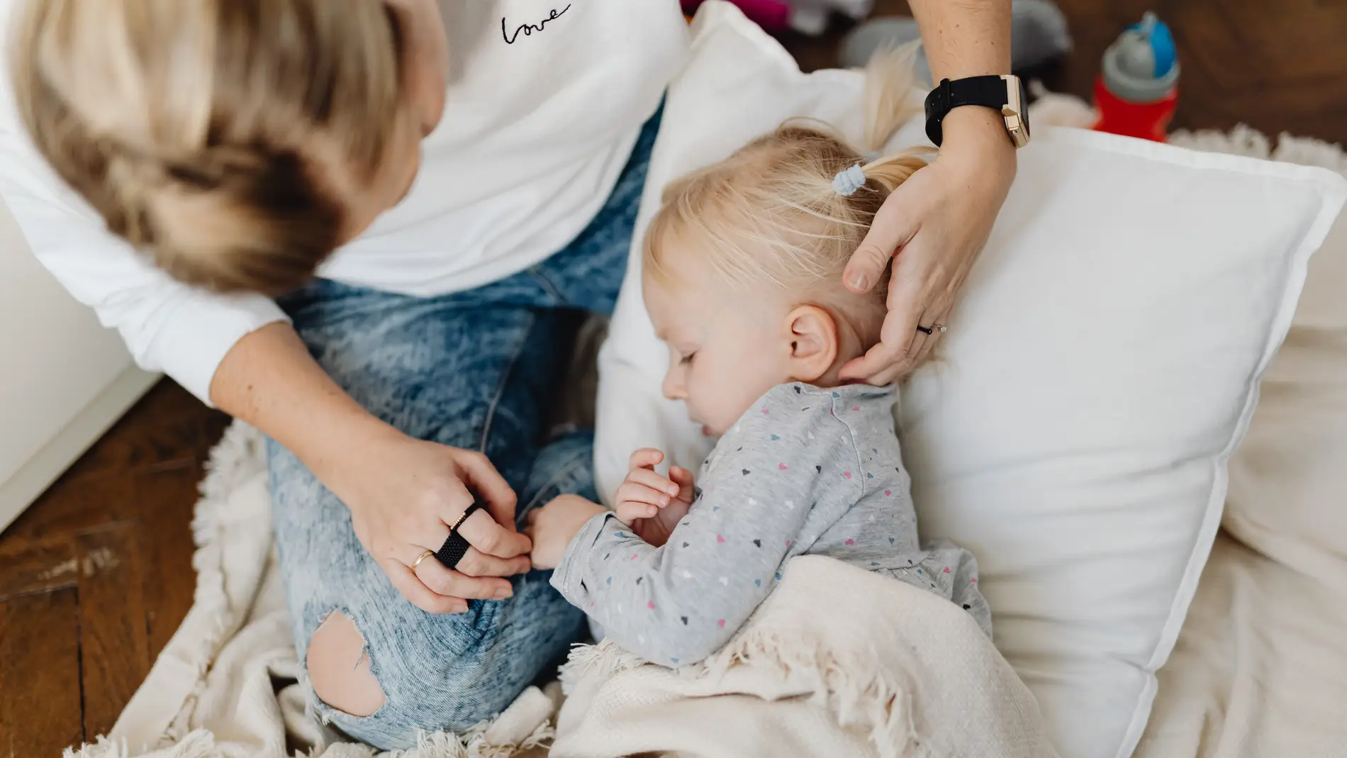 Madre acariciando a niña en la cama