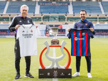 Ancelotti y Xavi posan con las respectivas camisetas de su equipo alrededor del trofeo de la Supercopa
