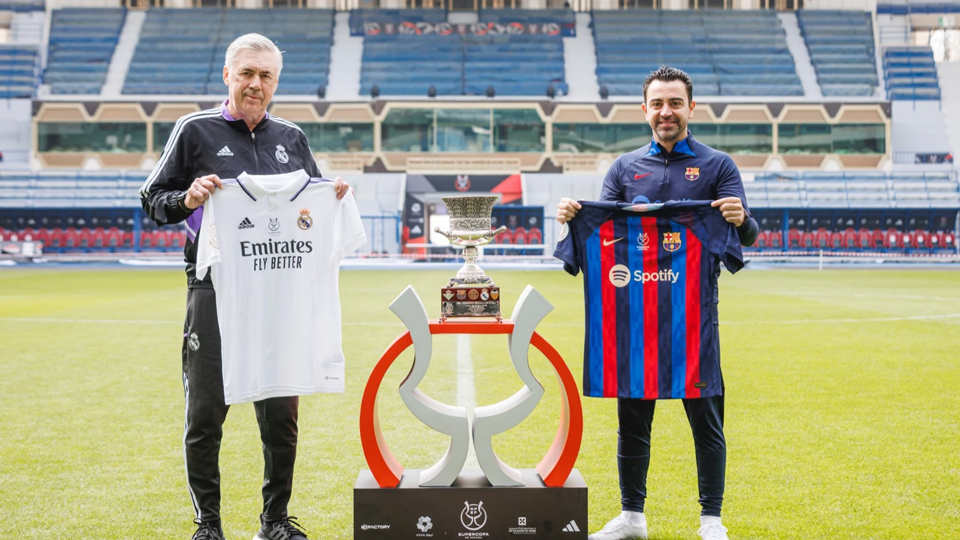 Ancelotti y Xavi posan con las respectivas camisetas de su equipo alrededor del trofeo de la Supercopa