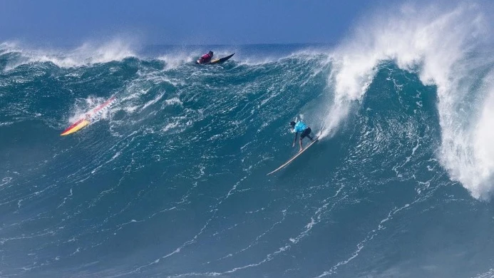 Un surfista desciende una ola en el Eddie Aikau Big Wave Invitational 2023
