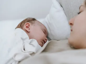 Un bebé duerme junto a su madre Un bebé duerme junto a su madre