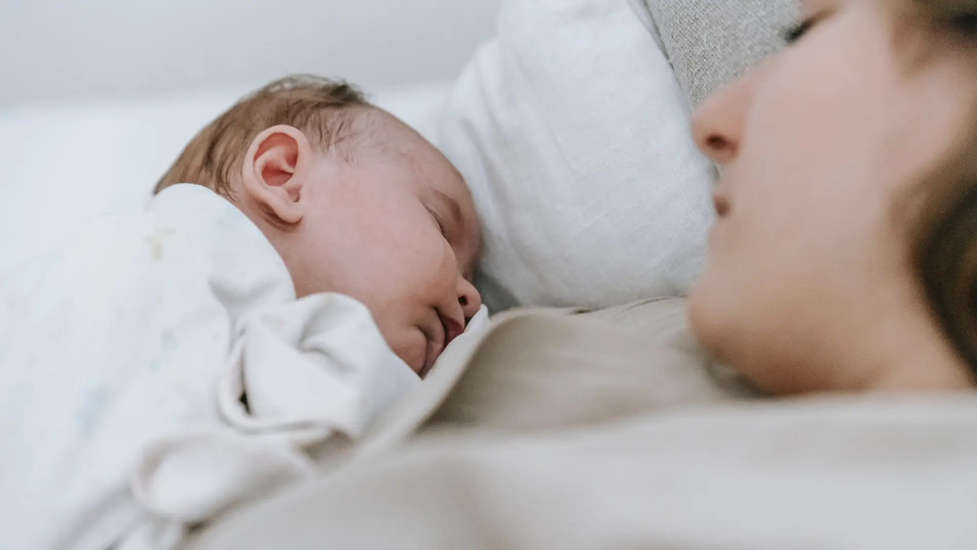 Un bebé duerme junto a su madre