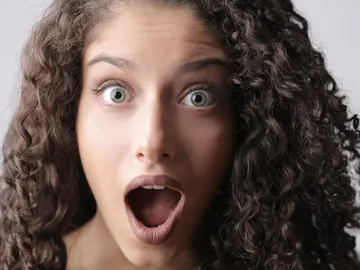 Chica con el pelo rizado sorprendida Chica con el pelo rizado sorprendida