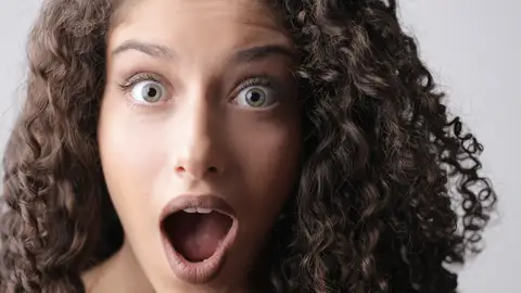 Chica con el pelo rizado sorprendida Chica con el pelo rizado sorprendida