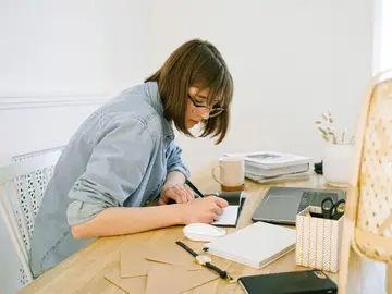 Imagen de archivo de una mujer tomando notas Imagen de archivo de una mujer tomando notas