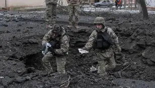 Militares ucranianos inspeccionan el cráter de un proyectil tras un ataque con cohetes en Donetsk