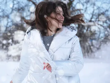 Chica abrigada en la nieve Chica abrigada en la nieve