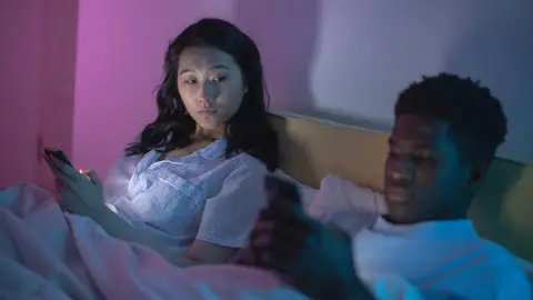 Chica mirando el móvil de su pareja Chica mirando el móvil de su pareja