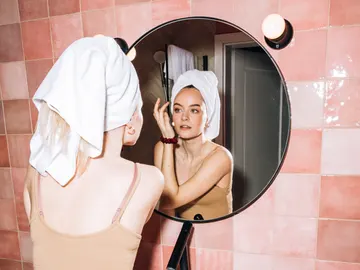 Una mujer se aplica productos cosméticos. Una mujer se aplica productos cosméticos.