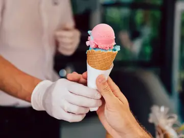 Un hombre ofrece un helado a una niña Un hombre ofrece un helado a una niña