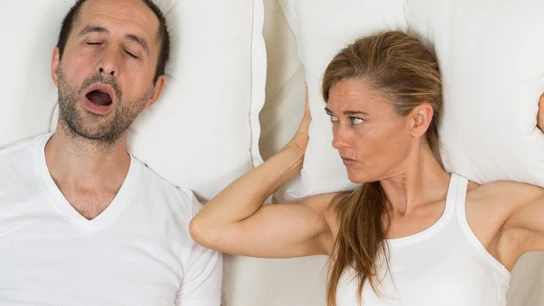 Mujer despierta mira a hombre que ronca Mujer despierta mira a hombre que ronca