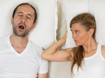 Mujer despierta mira a hombre que ronca Mujer despierta mira a hombre que ronca