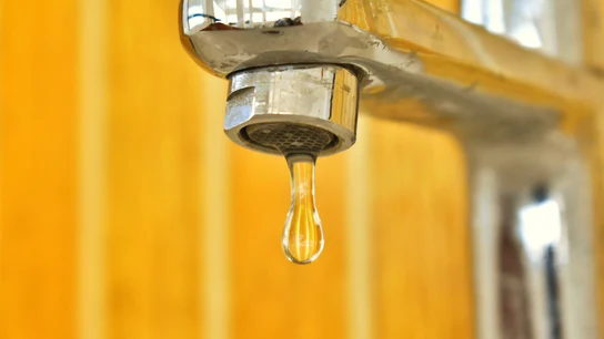 Imagen de una gota de agua saliendo del grifo Imagen de una gota de agua saliendo del grifo