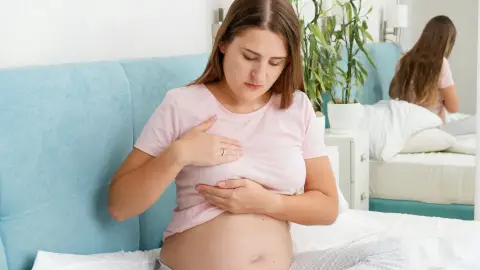Mujer embarazada tocándose el pecho