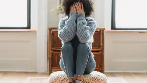Una mujer se tapa la cara con las manos Una mujer se tapa la cara con las manos