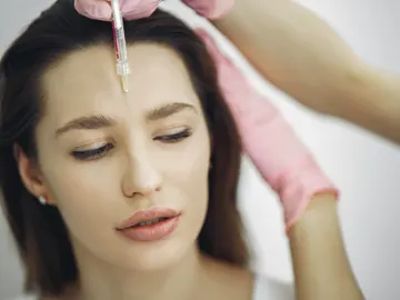 Una mujer se somete a un tratamiento de estética en el rostro Una mujer se somete a un tratamiento de estética en el rostro