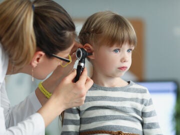 Una pediatra revisa el oído de una niña