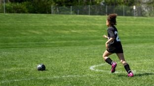 Imagen de archivo de un ni&ntilde;o corriendo en un campo de f&uacute;tbol
