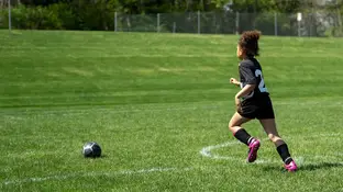Imagen de archivo de un niño corriendo en un campo de fútbol Imagen de archivo de un niño corriendo en un campo de fútbol