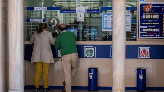 Dos personas comprando en una Administración de Lotería Dos personas comprando en una Administración de Lotería