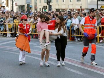 Una joven es evacuada durante la mascletá de las fallas de Valencia