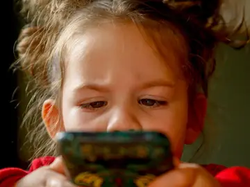 Niña con un móvil Niña con un móvil
