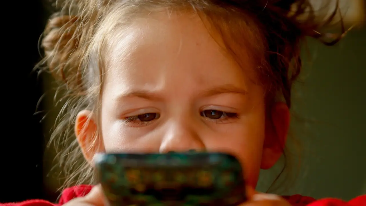 Niña con un móvil Niña con un móvil