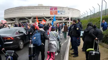 Pasajeros llegando a pie al aeropuerto de Charles de Gaulle por las protestas