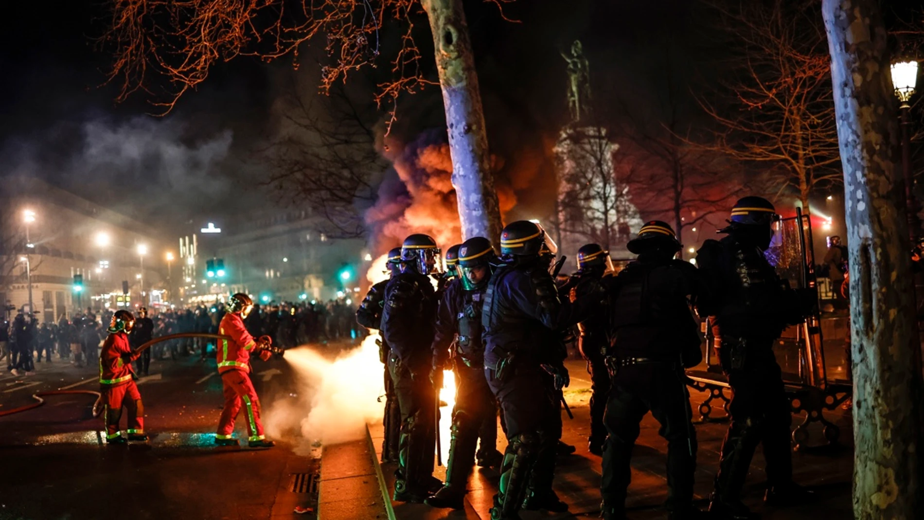 Bomberos apagan un fuego durante las protestas en París