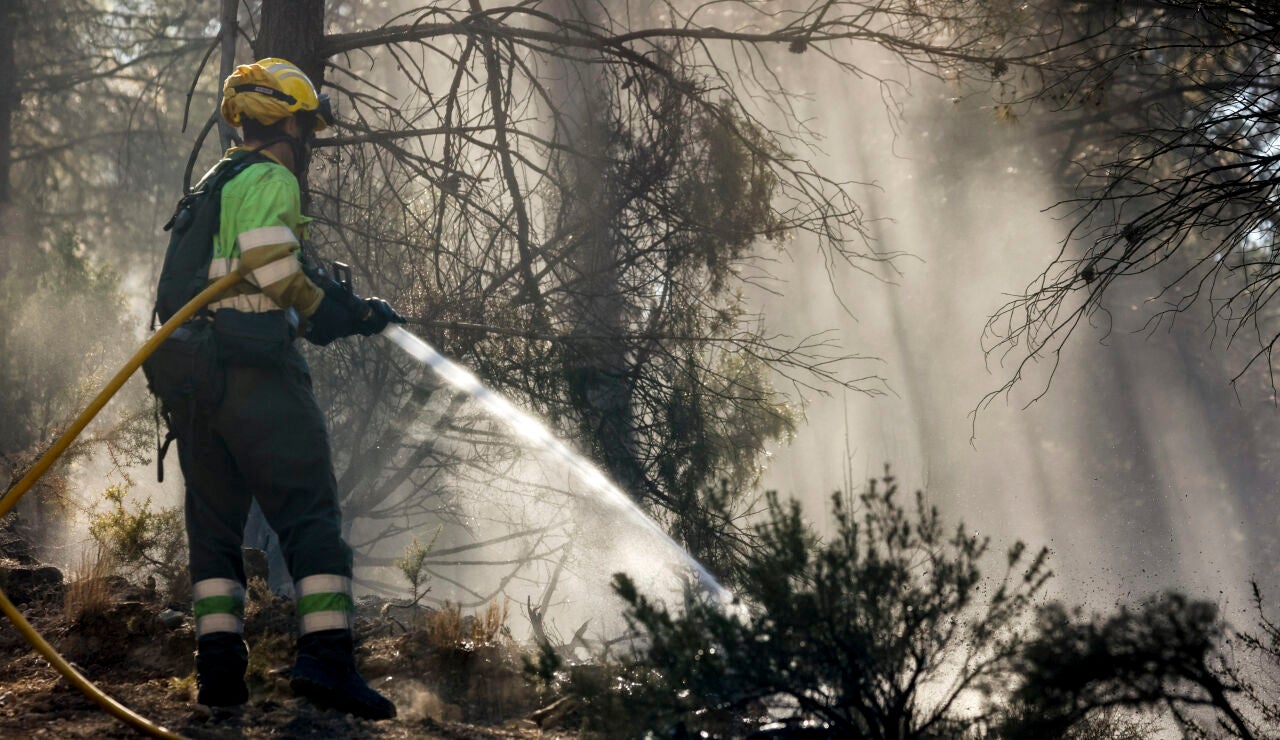 Un bombero refresca los alrededores de Montán