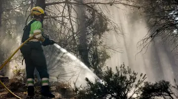 Un bombero refresca los alrededores de Montán Un bombero refresca los alrededores de Montán