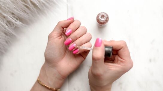 Persona se pinta las u&ntilde;as de color rosa