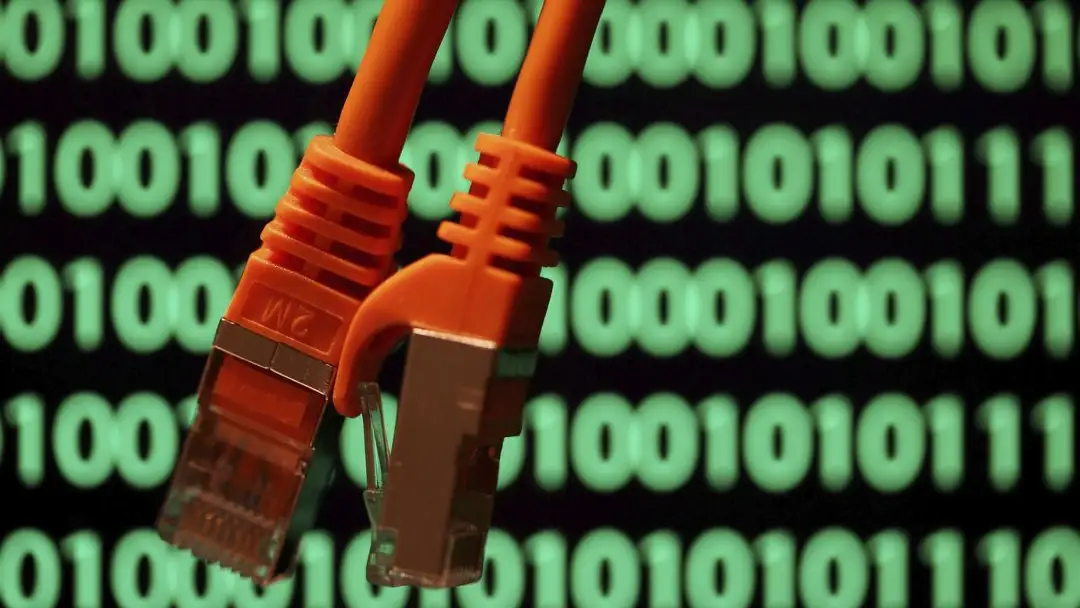 Imagen de archivo de unos cables sobre una pantalla de ordenador con un código binario Imagen de archivo de unos cables sobre una pantalla de ordenador con un código binario