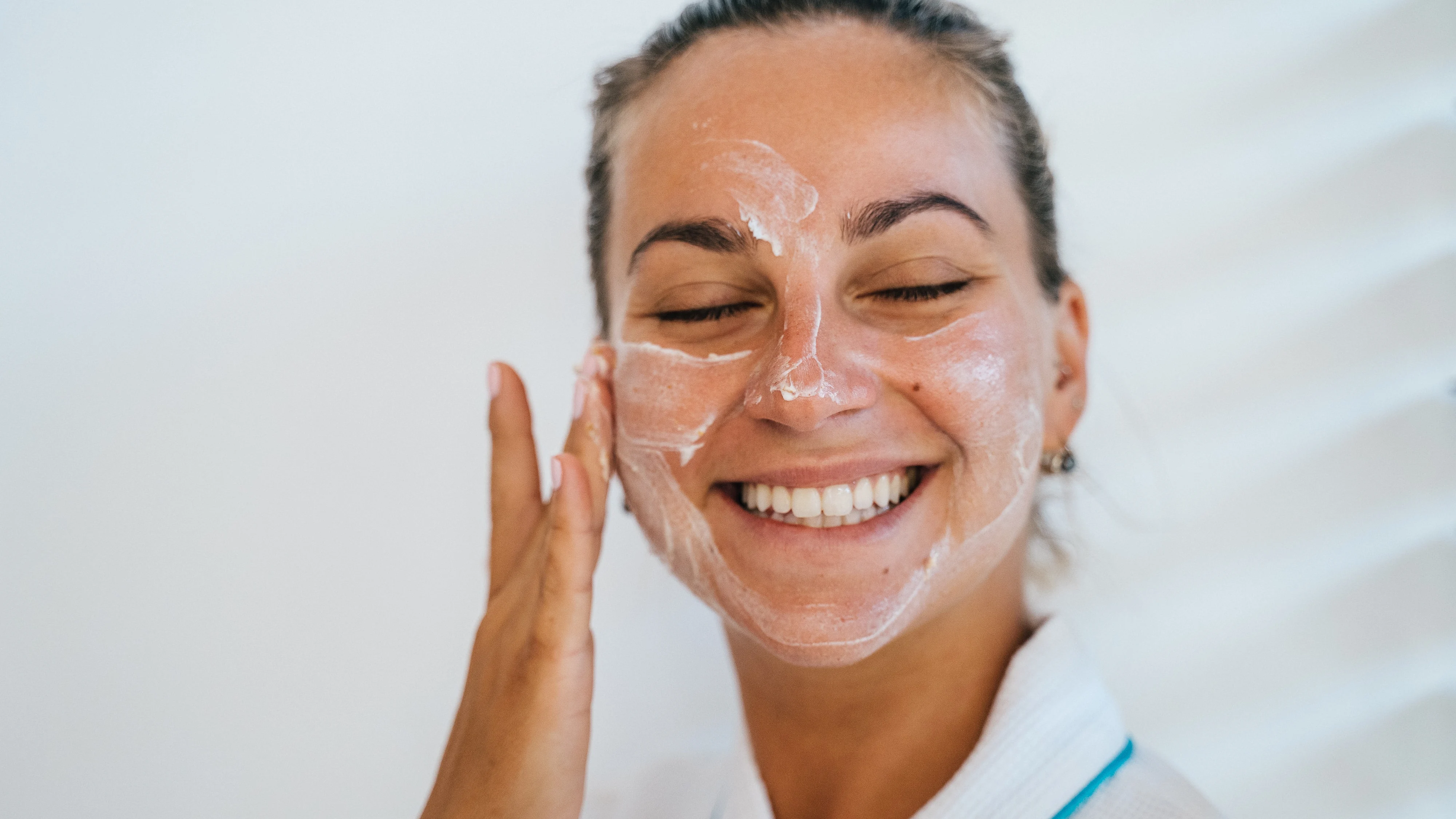 Mujer aplicándose un cosmético facial Mujer aplicándose un cosmético facial