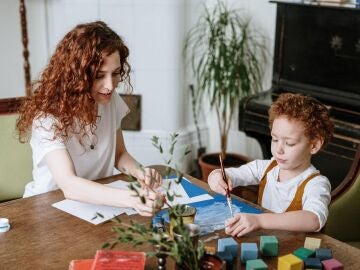 Una madre ayuda a su hijo a pintar