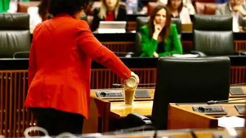 Maribel Mora, diputada de Adelante Andalucía, deposita un vaso de arena seca en el escaño de Moreno Maribel Mora, diputada de Adelante Andalucía, deposita un vaso de arena seca en el escaño de Moreno