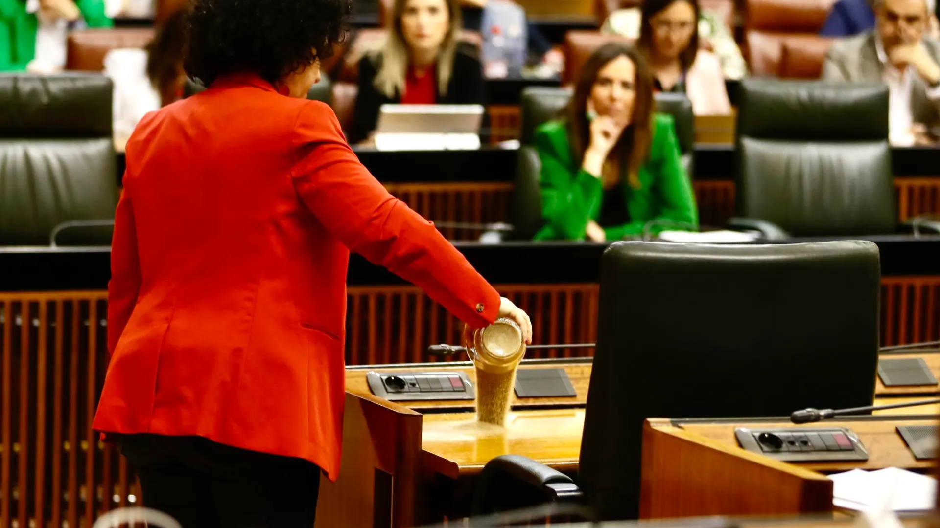 Maribel Mora, diputada de Adelante Andaluc&iacute;a, deposita un vaso de arena seca en el esca&ntilde;o de Moreno
