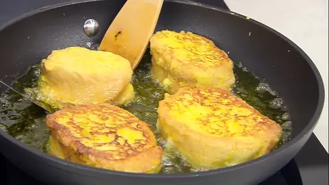 Reboza las rebanadas de pan con el huevo batido e introdúcelas en la sartén Reboza las rebanadas de pan con el huevo batido e introdúcelas en la sartén