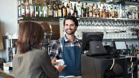 Camarero atendiendo a una clienta en un bar